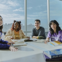 Four students sit at a table