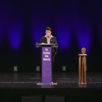 Lynn Mahoney speaking at a podium