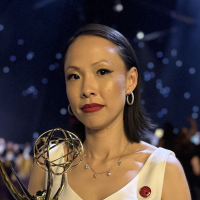 Poh Si Teng holds her Emmy Award statuette while standing at the awards ceremony