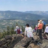 Students on a mountain top looking at a scenic view