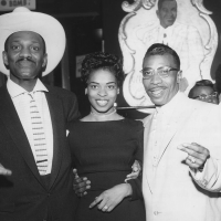 Wesley Johnson, a woman and blues musician T-Bone Walker pose for a picture while standing inside the Texas Playhouse nightclub