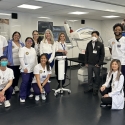 Eight nursing students stand in a lab