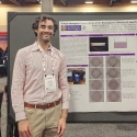 Sergio standing next to his poster at a science conference